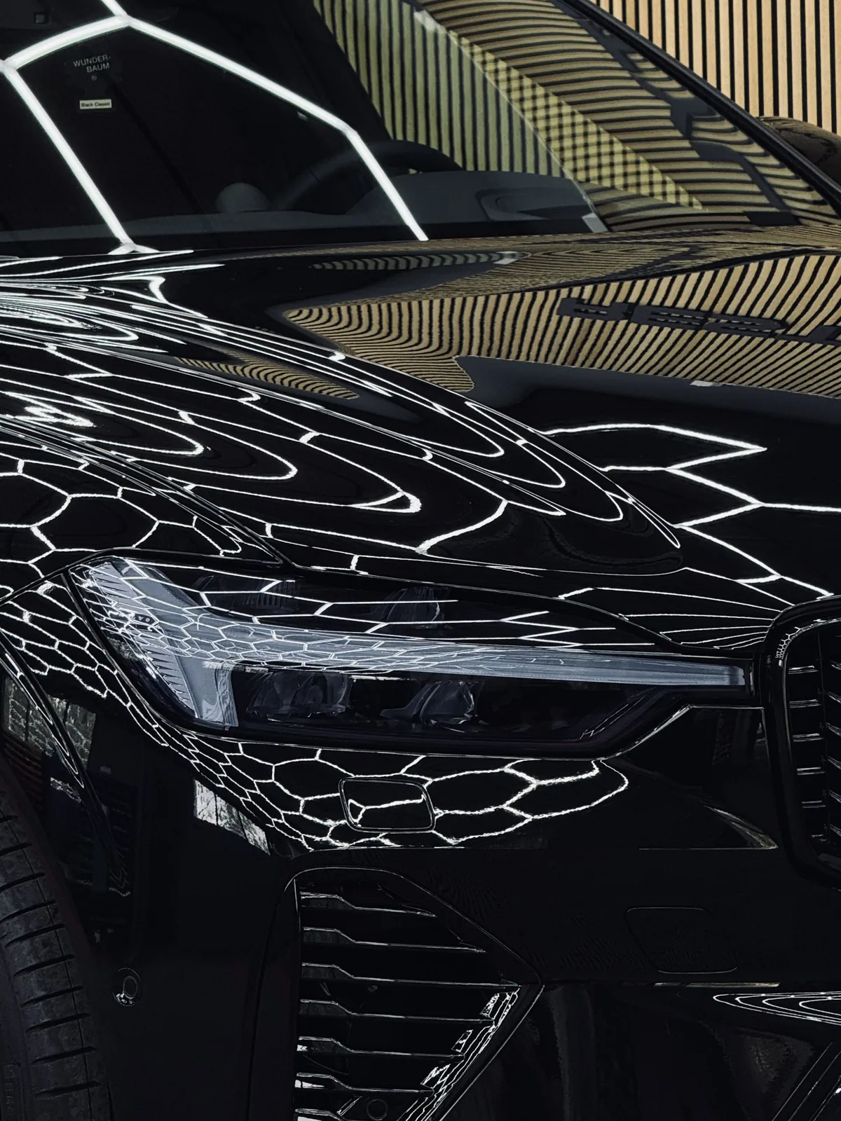 Mustan Volvo XC60:n konepelti ja ajovalo lähikuvassa