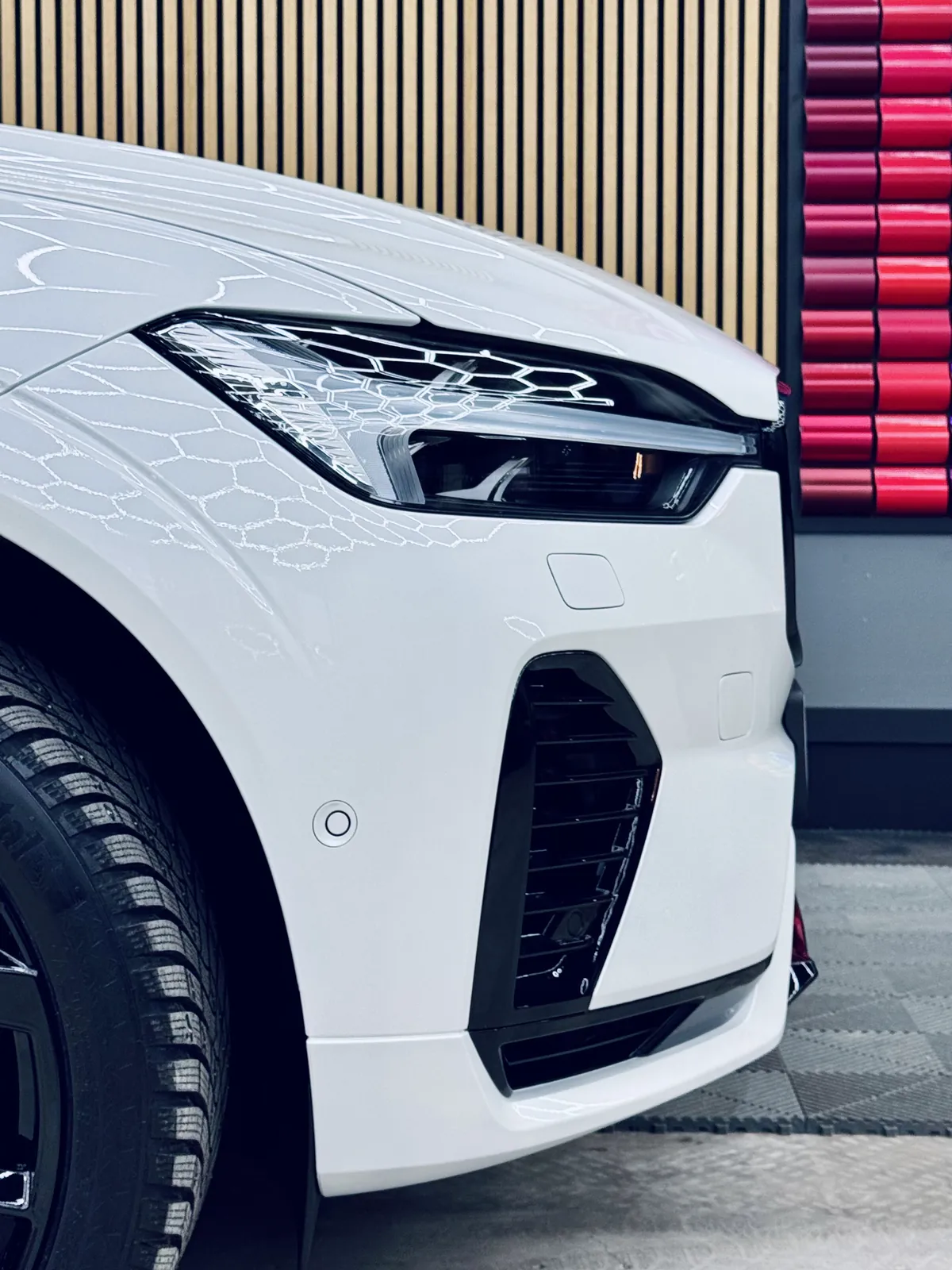 Valkoisen Volvo XC60:n ajovalo ja etupuskurin kulma